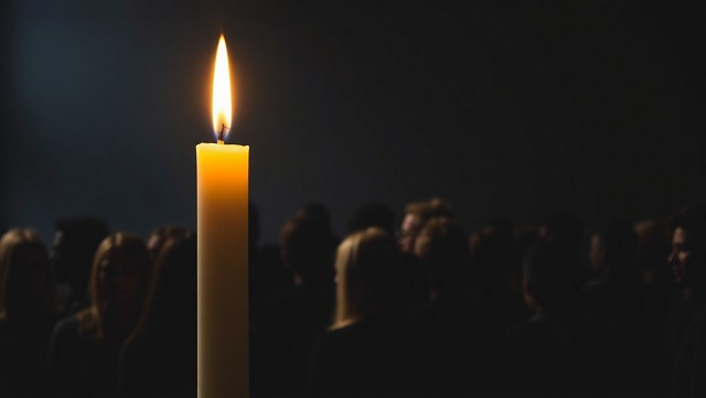 Symboliczna świeca pamięci z kolorowym cieniem ludzi różnych kul