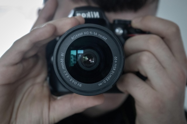 Zbliżenie aparatu fotograficznego w dłoniach fotografa